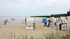 Beach chairs and umbrellas on a sandy beach with the sea in the background. - Apartment Wiesenschein, Moenkebude (Monkebude)