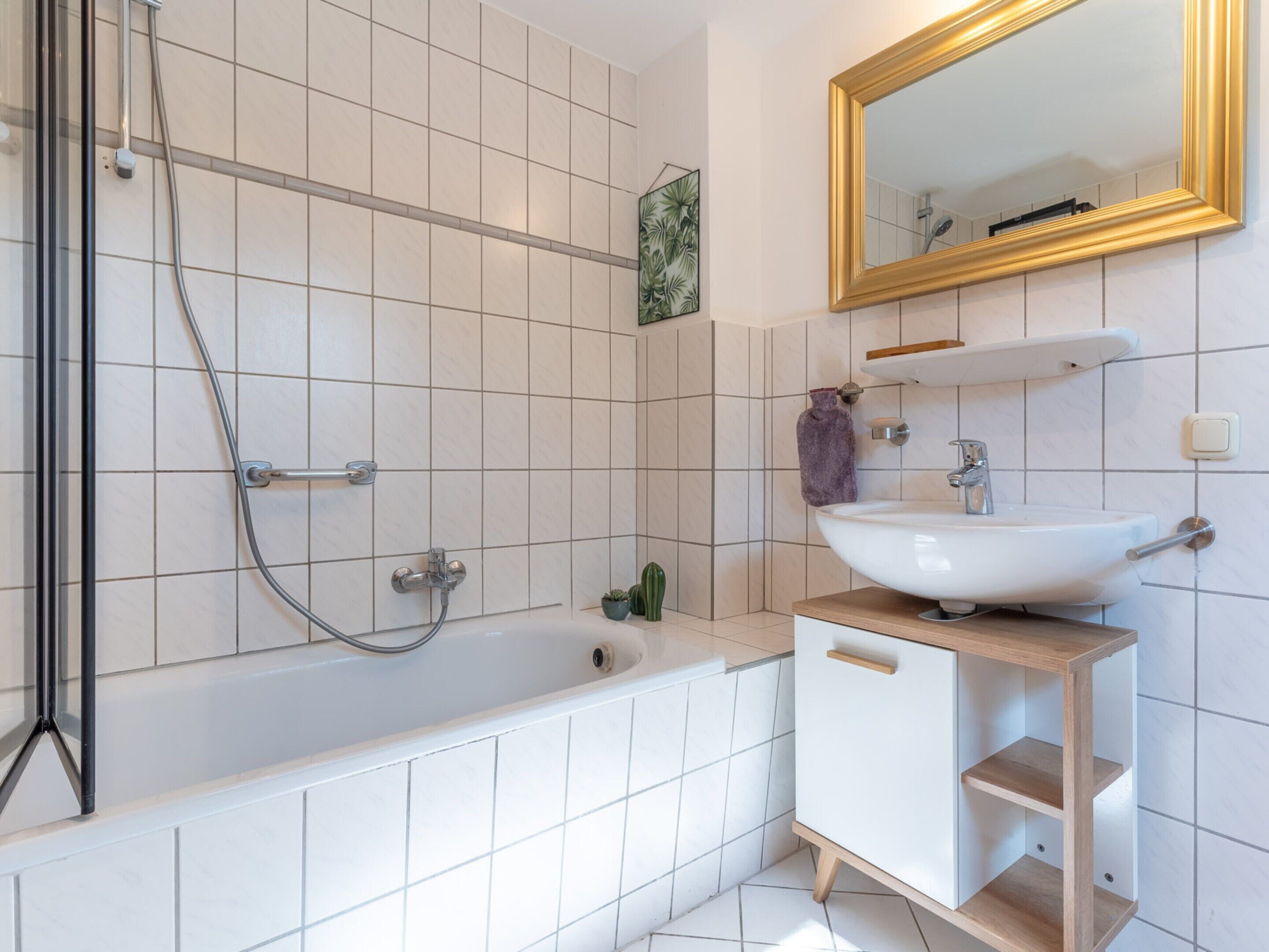 A modern bathroom with a bathtub, shower, and sink.