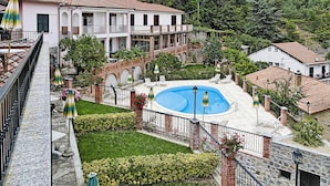 A pool surrounded by a garden, with a building in the background. - Apartment in Castellaro With Balcony (Casanova Lerrone)