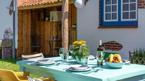 A table set outdoors with plates, glasses, and a bowl of fruit. - Holiday Home in Tating (Tating)