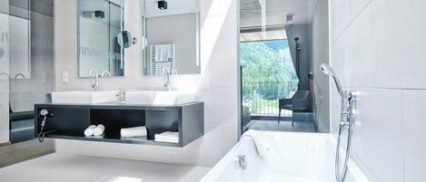 Un baño moderno con una bañera amplia, un lavabo doble y un espejo grande.
