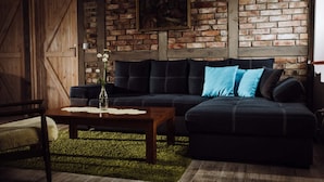 A living room with a dark sofa, a wooden coffee table, and a green rug. - Apartment in Gronowo Near Lake Siecino (Zlocieniec)