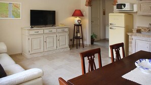 A compact living space with a television, a dining table, and a kitchenette area. - Villa in Camaiore Near Sandy Beaches (Camaiore)