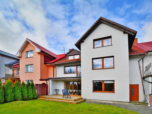 A modern multi-story residential building with a flat roof, large windows, and a well-maintained lawn. - Comfortable Holiday Villa, Private Garden (Kolobrzeg)