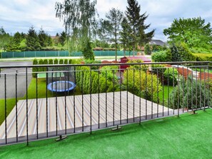 A rooftop terrace with a trampoline, green lawn, and a tennis court in the background. - Comfortable Holiday Villa, Private Garden (Kolobrzeg)