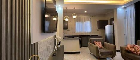 A modern living room with a sofa, a coffee table, and a TV mounted on the wall.
