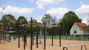 A playground with climbing structures and a bench.