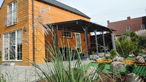 A modern two-story house with a wooden exterior and a covered porch. - Holiday Home in Stepnica Near Szczecin Lagoon (Stepnica)