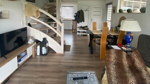 A spacious living area with a wooden staircase, a TV, a coffee table, and a sofa. - Holiday Home in Stepnica Near Szczecin Lagoon (Stepnica)
