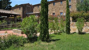 A stone building with multiple windows and a covered patio area. - Apartment in Campiglia Marittima (Campiglia Marittima)
