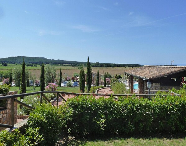 A villa with a pool, surrounded by lush greenery and a view of rolling hills. - Apartment in Campiglia Marittima (Campiglia Marittima)
