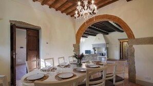 Un coin repas avec une table ronde dressée pour six personnes, entourée de six chaises.