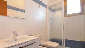 Un baño con ducha, inodoro y lavabo.