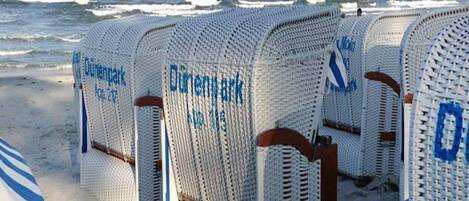 Beach chairs labeled "Diengpark" arranged on a sandy beach with the ocean in the background.