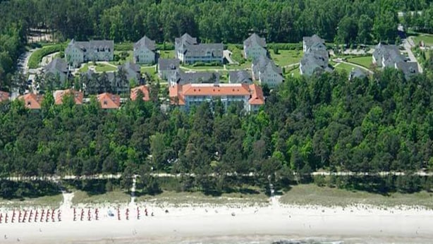Luftaufnahme einer Küstenregion mit einer Reihe von Häusern und einem Strand.