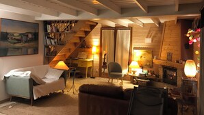 Ein gemütliches Wohnzimmer mit Treppe, Kamin und Bücherregal.