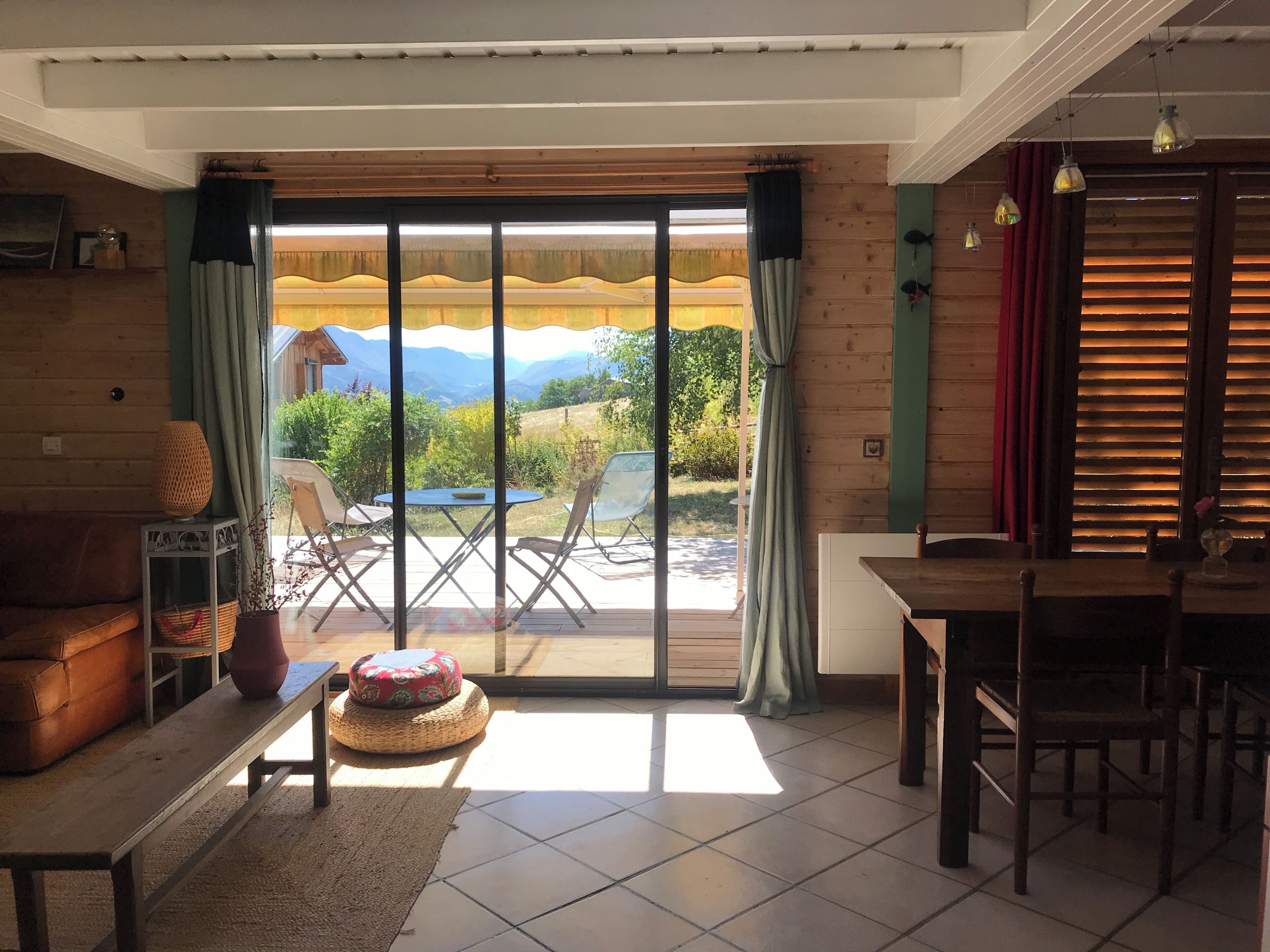 A room with a sliding glass door leading to an outdoor area with a table and chairs.