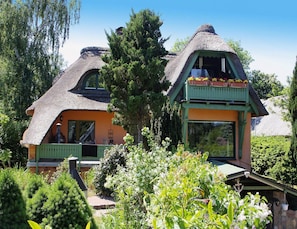 A house with a thatched roof and a green porch area. - Ferienhaus, Damerow (Jabel)