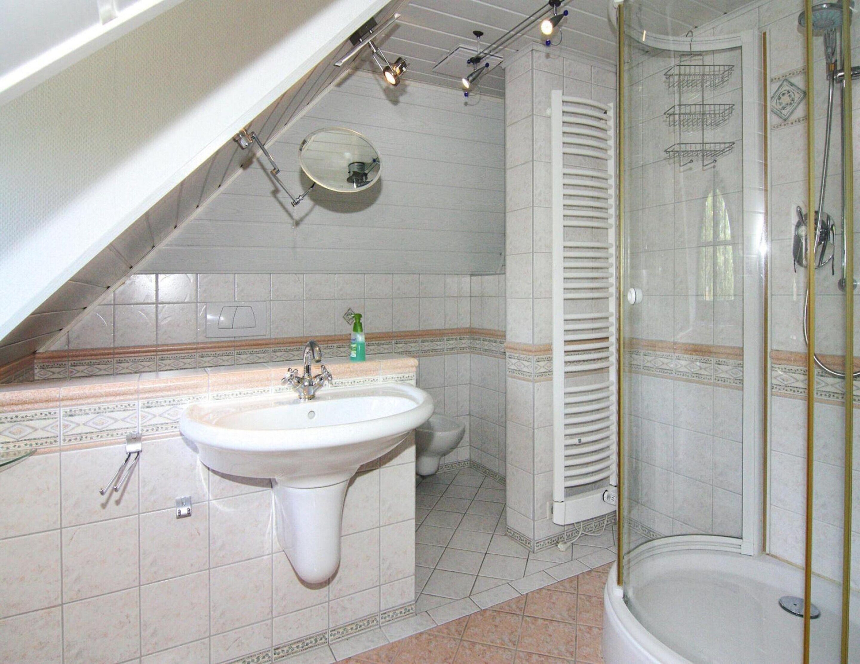 A bathroom with a sink, toilet, and shower.