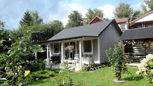 Une maison à deux étages avec un porche abrité et un petit jardin.