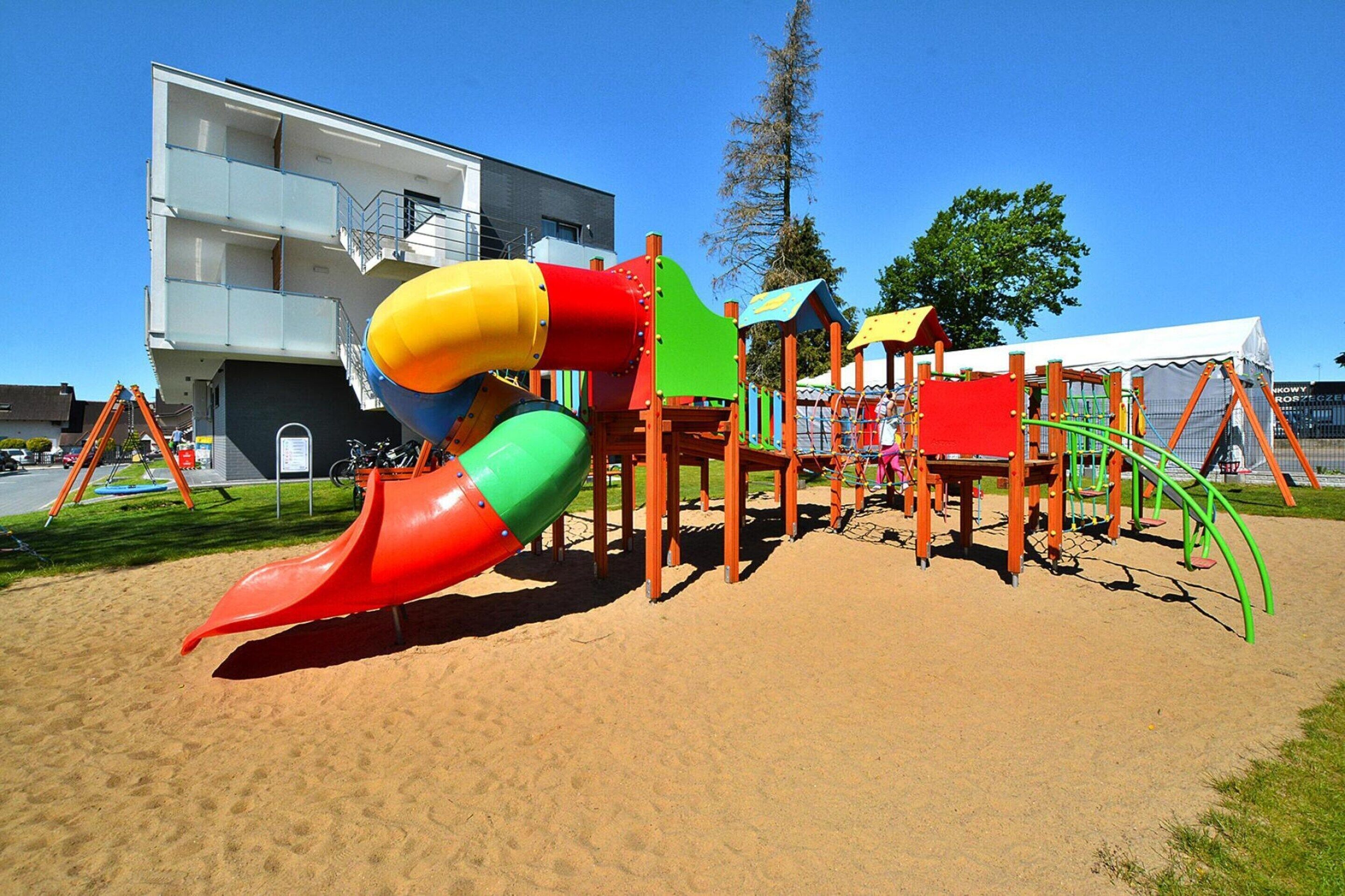 A playground with a slide, climbing structures, and a covered area.