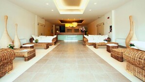 A reception area with a central desk, two wicker sofas, and a tiled floor. - Residence Riviera Palace, Loano (Loano)
