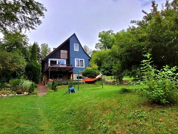 A blue house with a sloped roof and a covered porch. - Holiday Home Right on the Lake, Florczaki (Lukta)
