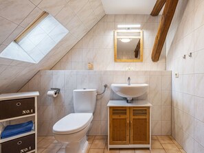 A bathroom with a toilet, sink, and wooden cabinets. - Studio in Buchholz am Muritzsee (Buchholz)