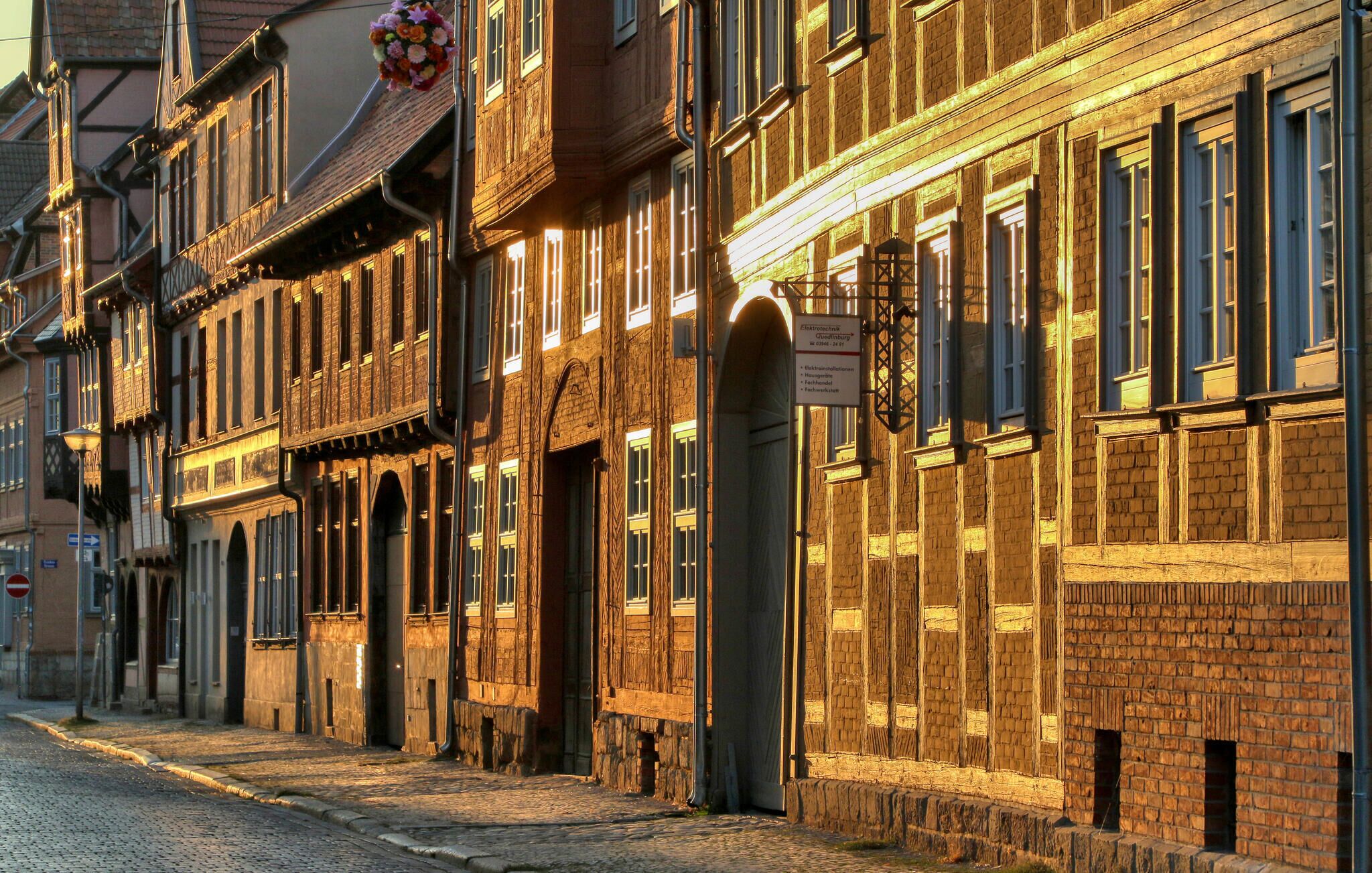 A cobblestone street lined with historic buildings featuring timber framing and brick facades.