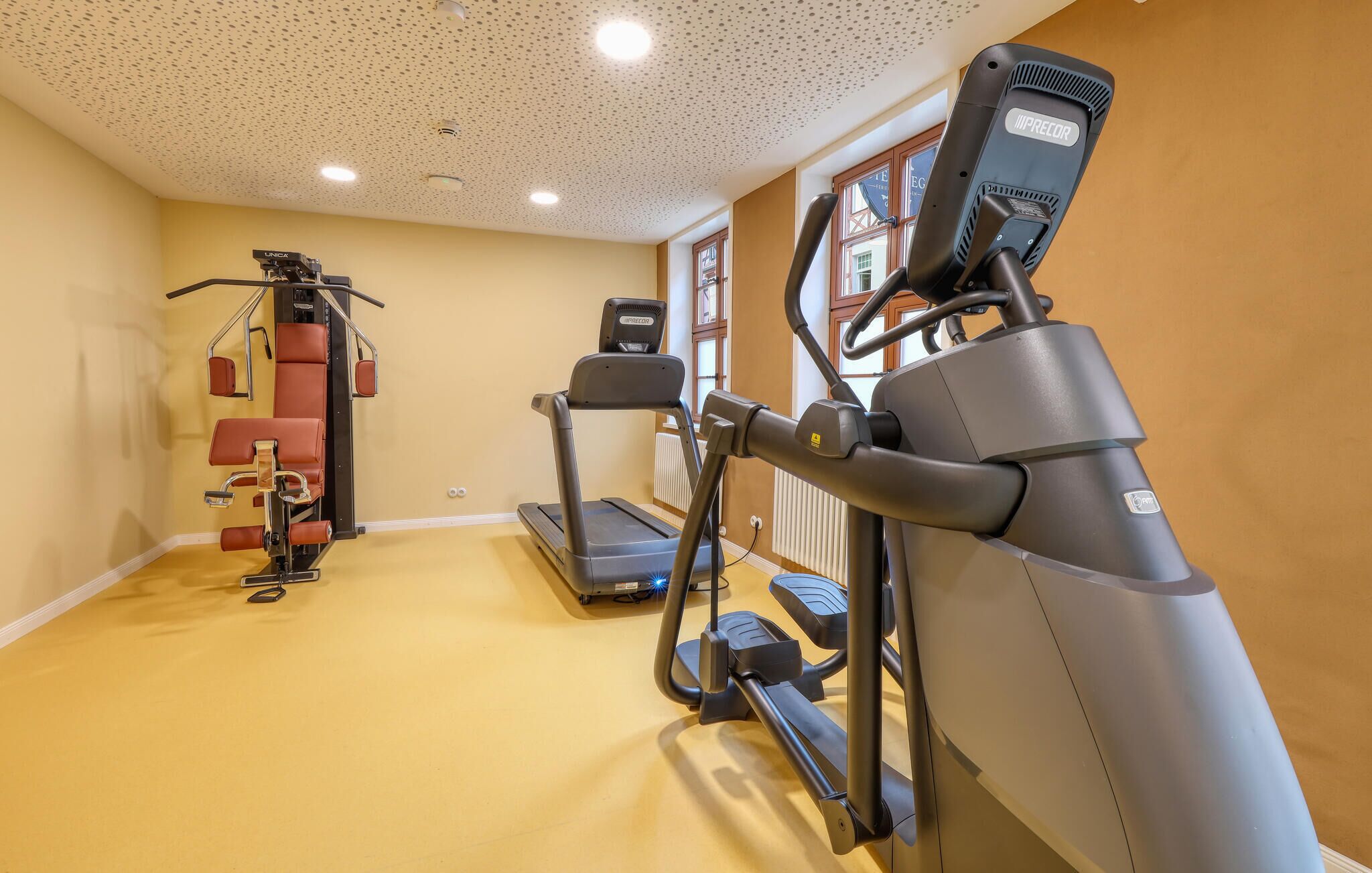 Une salle de remise en forme équipée de tapis de course, de vélos elliptiques et de matériel de musculation.