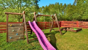 A playground with a wooden slide and climbing wall. - Holiday Apartment in the Countryside, Biskupice (Biały Bór)