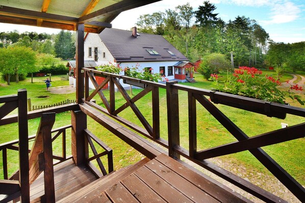 Une terrasse en bois offrant une vue sur une maison et un jardin.