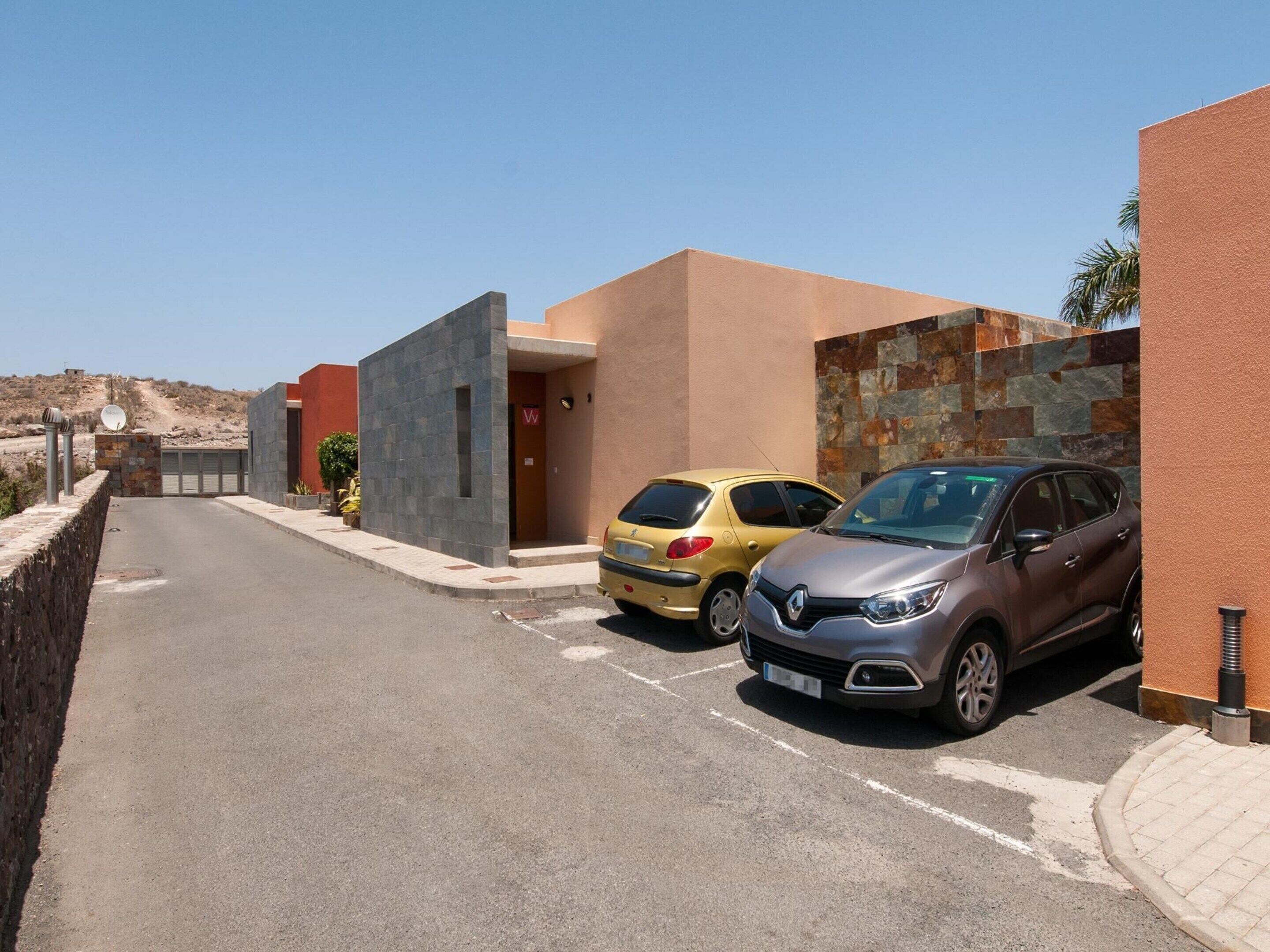 A residential street with two cars parked in front of houses.