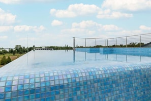 An infinity pool with a clear view of the sky and distant landscape.