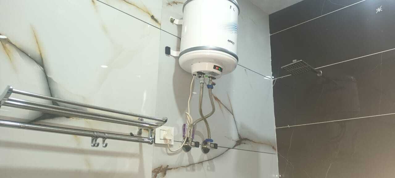 A bathroom with a white marble wall, a shower area, and a towel rack.