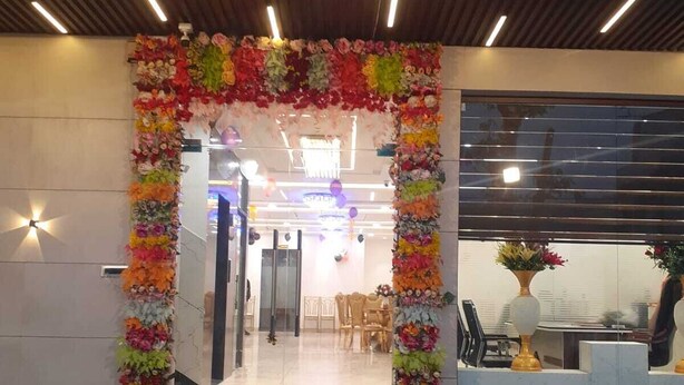 En hotelindgang med en blomsterpyntet bue og et skilt med teksten "THE DIVINE".