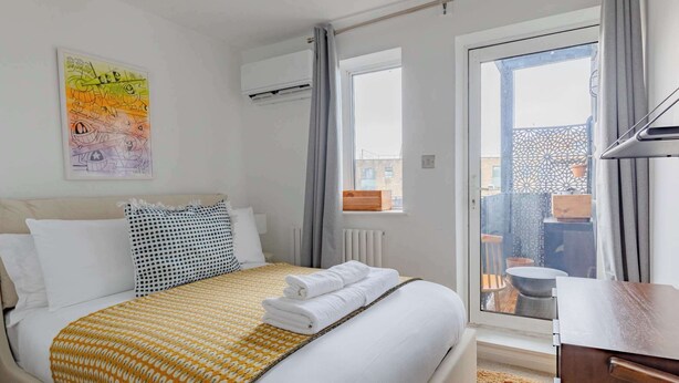 Une chambre d’hôtel équipée d’un lit, d’une fenêtre, d’un appareil de climatisation et offrant une vue sur l’extérieur.