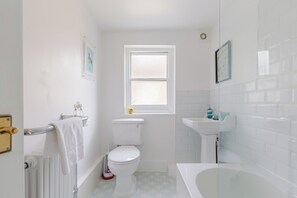A bathroom with a toilet, sink, and bathtub.