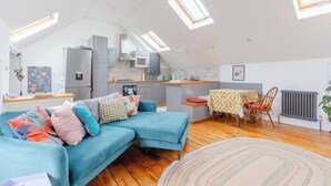 A modern loft-style apartment with a kitchen, dining area, and living space.