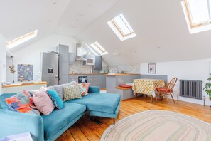 A modern loft-style apartment with a kitchen, dining area, and living space.