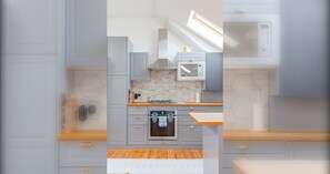 Une cuisine moderne avec des meubles de couleur grise, un four encastré et un four à micro-ondes.
