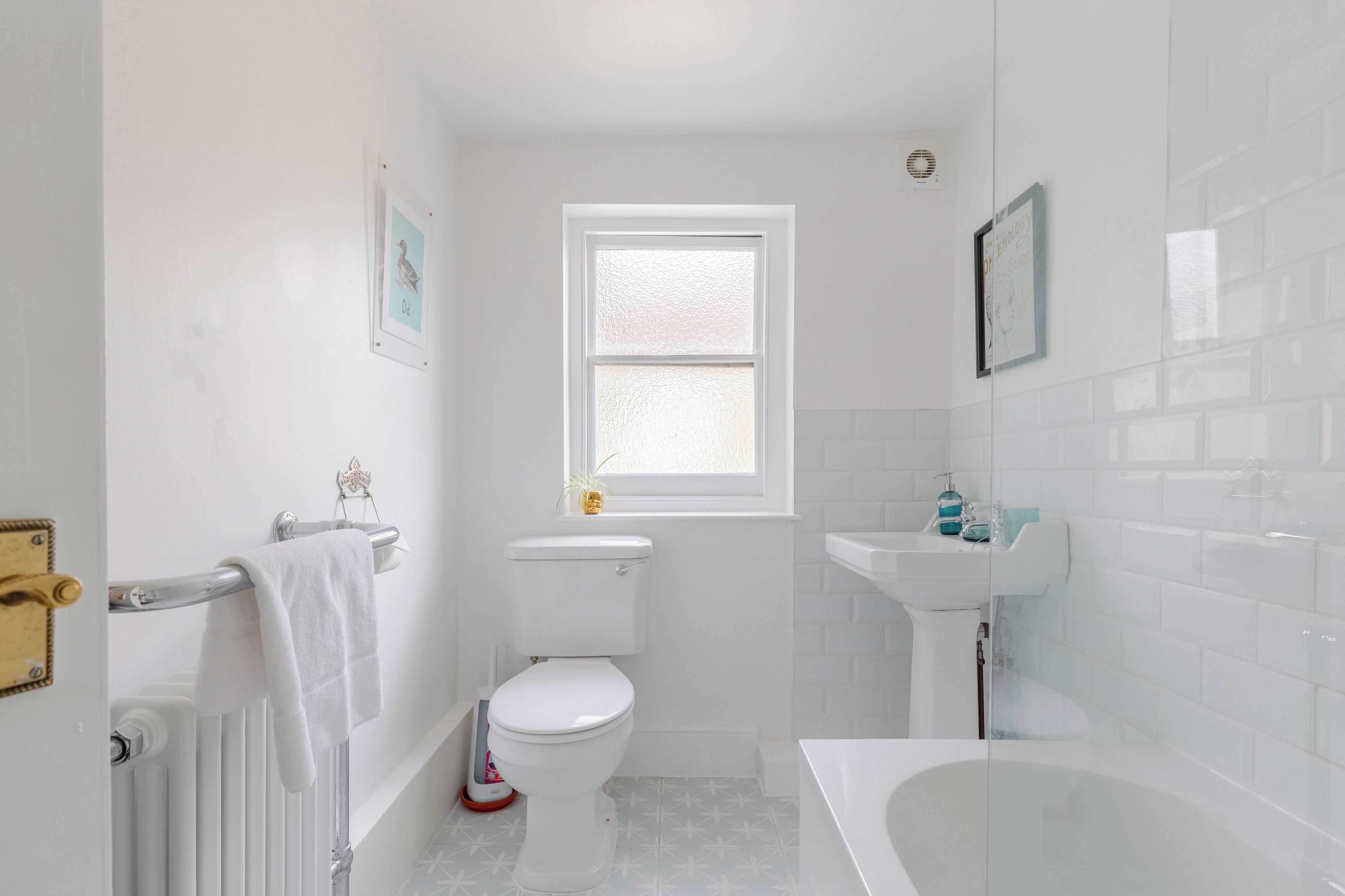 Een badkamer met toilet, wastafel en bad.