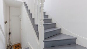 A staircase with white balusters and grey steps leading to a landing.