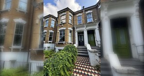 A multi-story brick building with a traditional facade, a green door, and a checkered floor pattern.