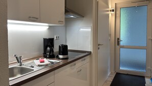 Een moderne keuken met een spoelbak, koffiezetapparaat en kasten.