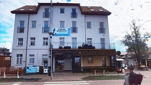 A multi-story building with a flat facade, several windows, and a visible ground-floor entrance. - Comfortable Apartment With a sea View (Ustronie Morskie)