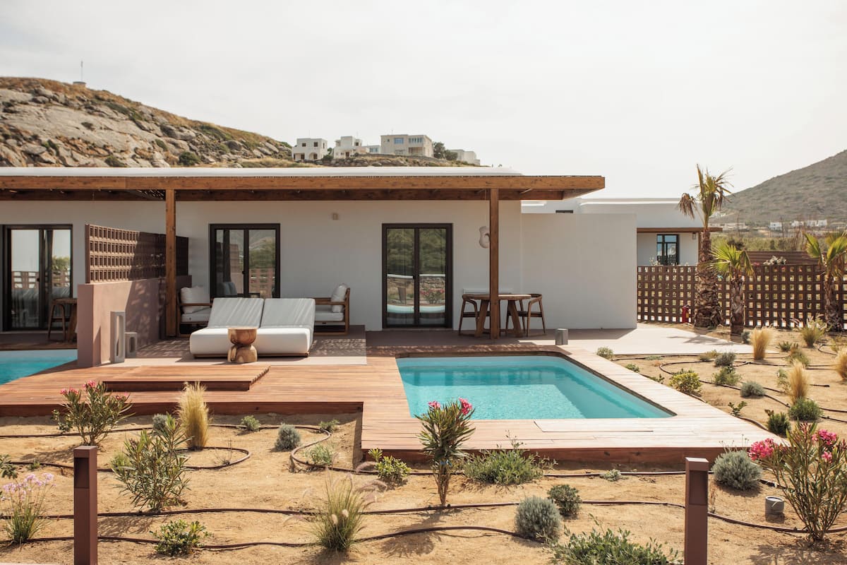 A modern house with a swimming pool, outdoor seating, and a desert garden.