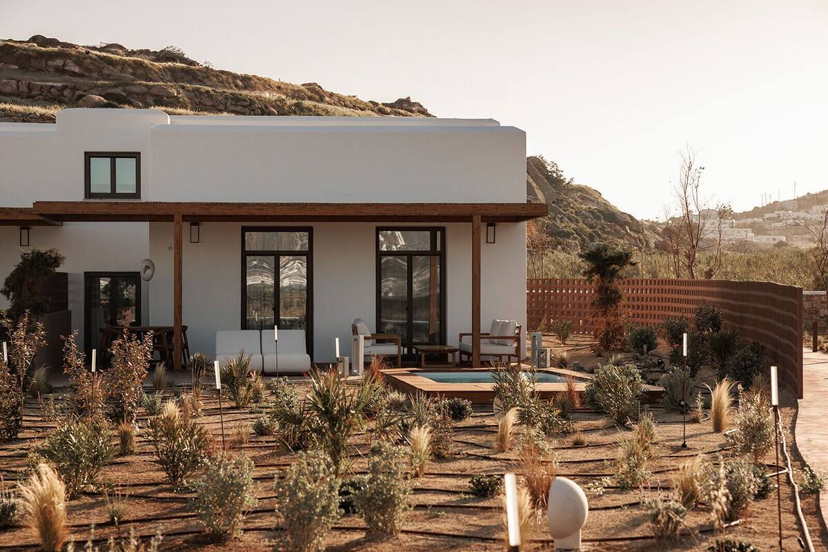 A modern house with a pool, surrounded by desert vegetation.