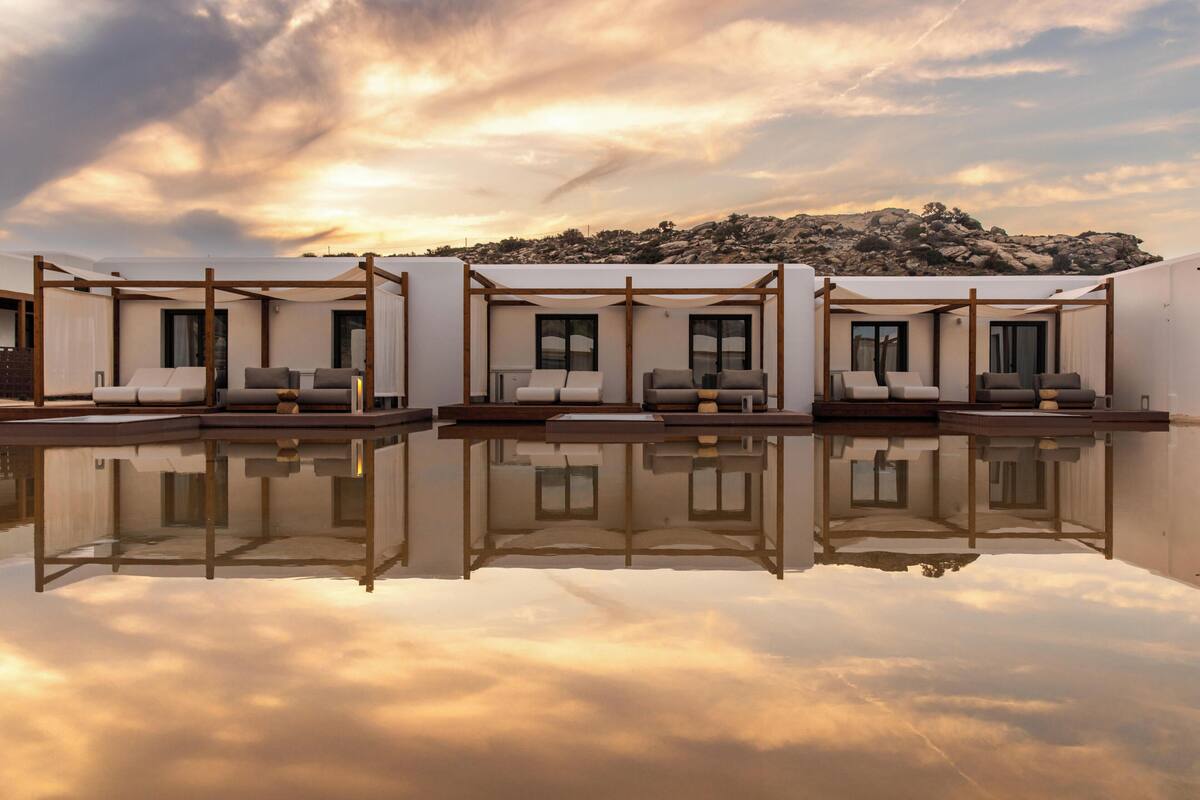 A poolside area with multiple seating arrangements and a view of a rocky landscape.