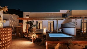 A modern outdoor living area with a pool, seating, and a covered patio. - Laguna Coast Resort, Small Luxury Hotels of the World (Naxos)